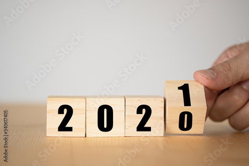 Hand flipping wooden blocks for change year 2020 to 2021 . New year and holiday concept.