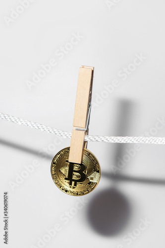 Bitcoin is hung on a rope with clothespins.