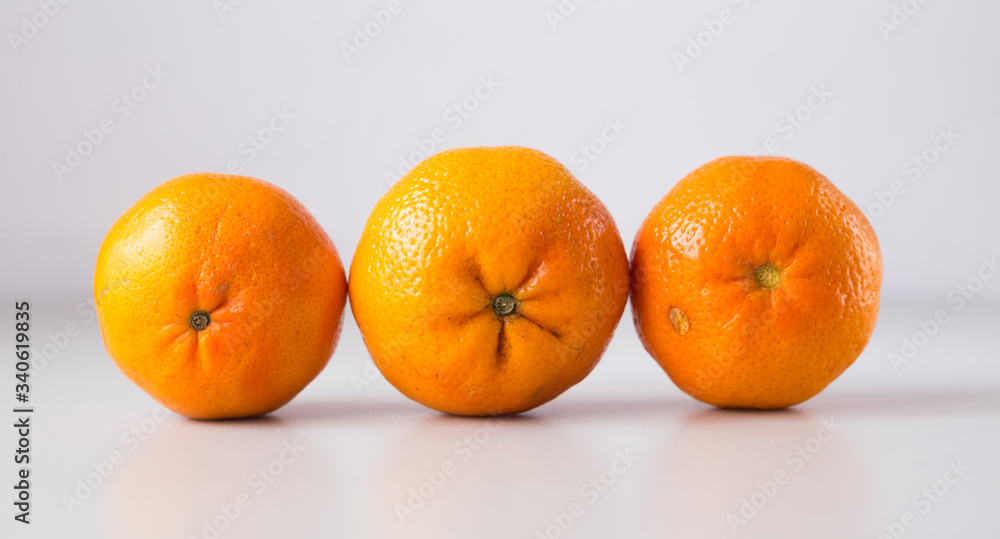 appetizing tangerines laid out in a row on white background appetizing tangerines laid out in a row on white background