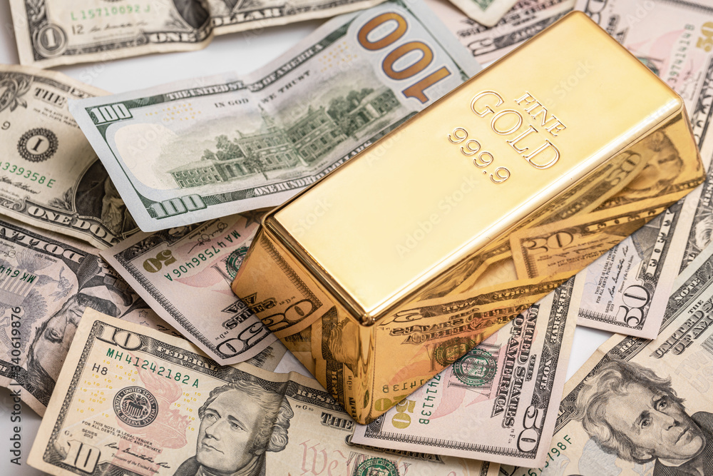 Gold bar and US dollar bills Gold bar and US dollar bills