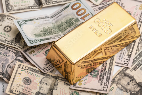 Gold bar and US dollar bills