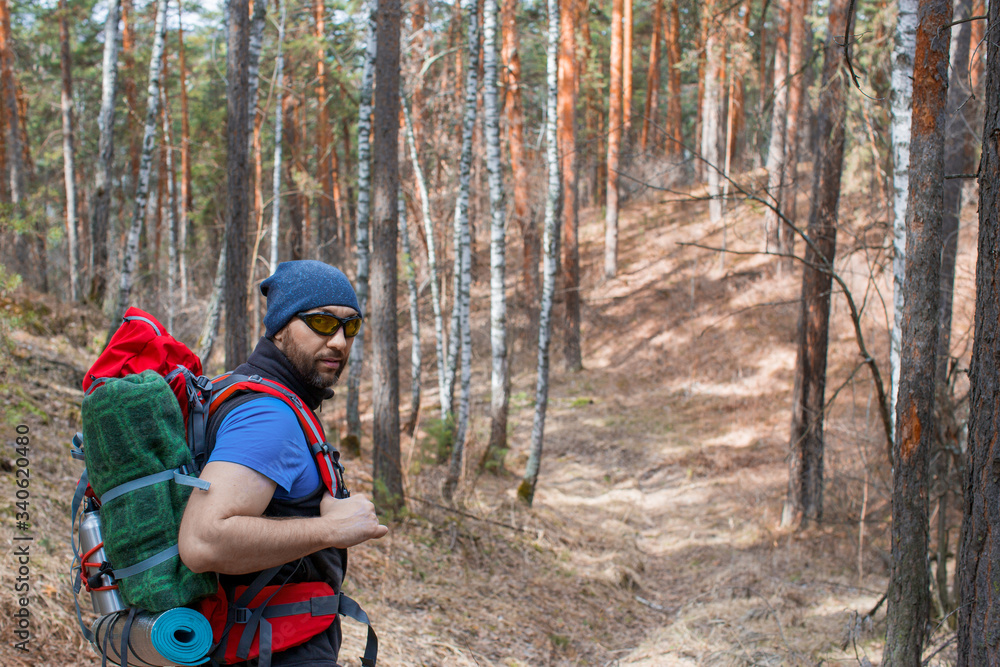 Male tourist with a backpack in the forest. Close up portrarit.