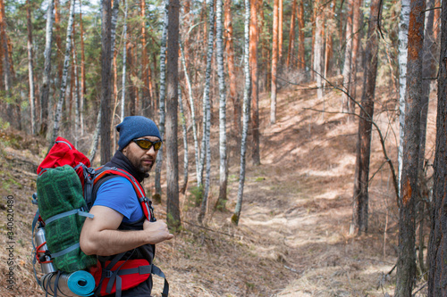 Male tourist with a backpack in the forest. Close up portrarit.