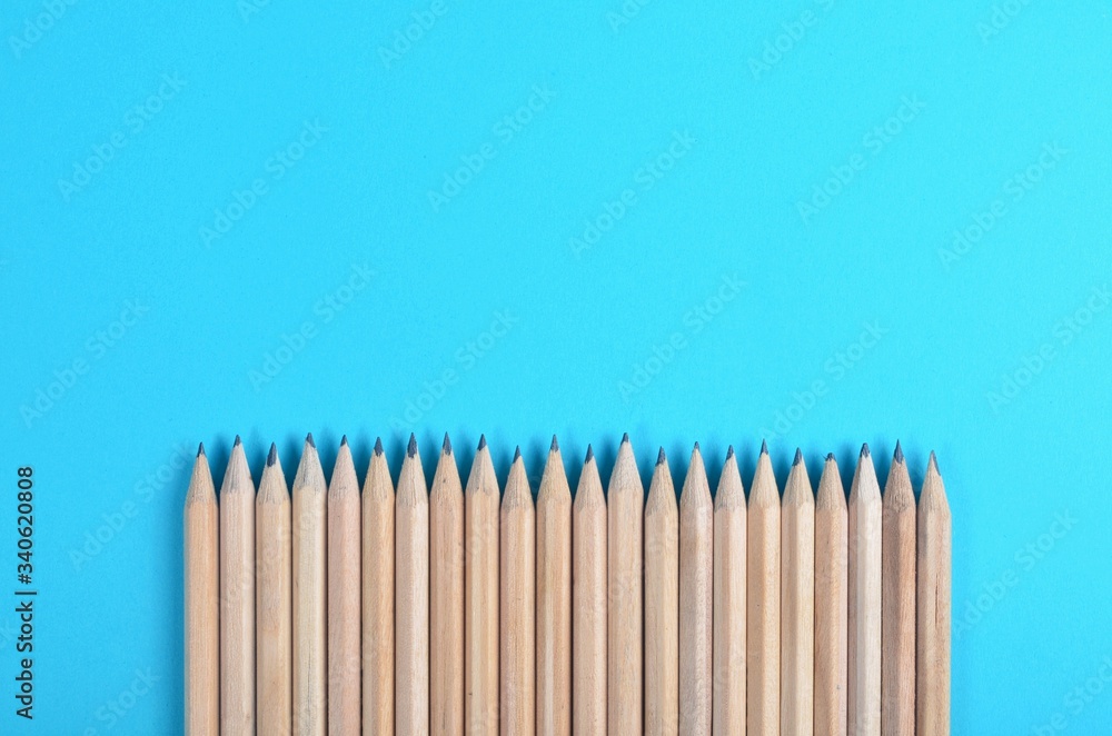 Lot of wooden pencils on blue paper background Lot of wooden pencils on blue paper background