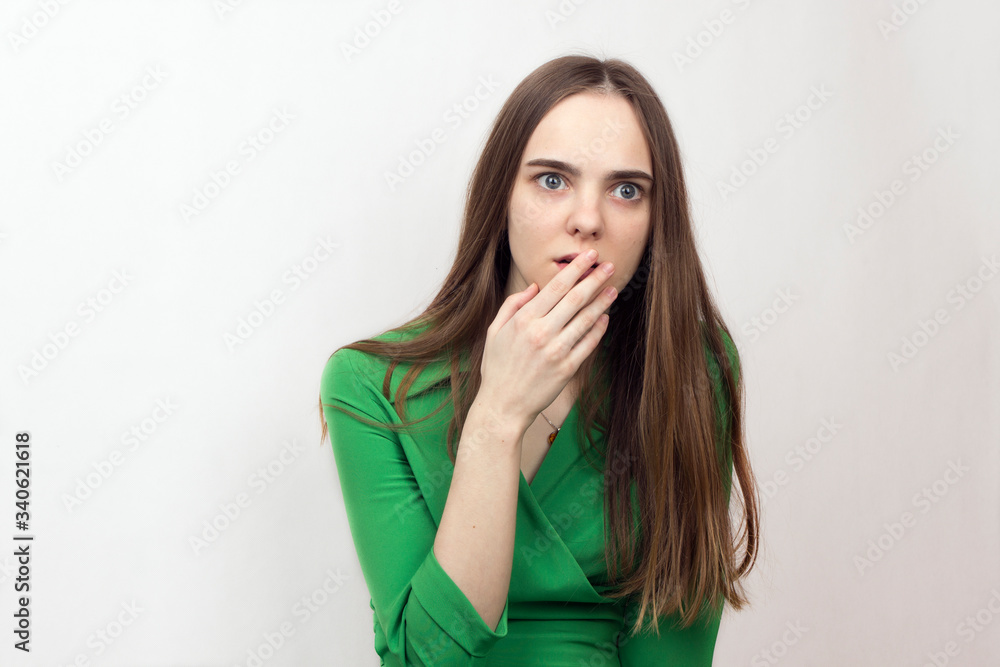 beautiful young long-haired girl with gray eyes is very scared, afraid, panicked and covers her mouth with her hand beautiful young long-haired girl with gray eyes is very scared, afraid, panicked and covers her mouth with her hand