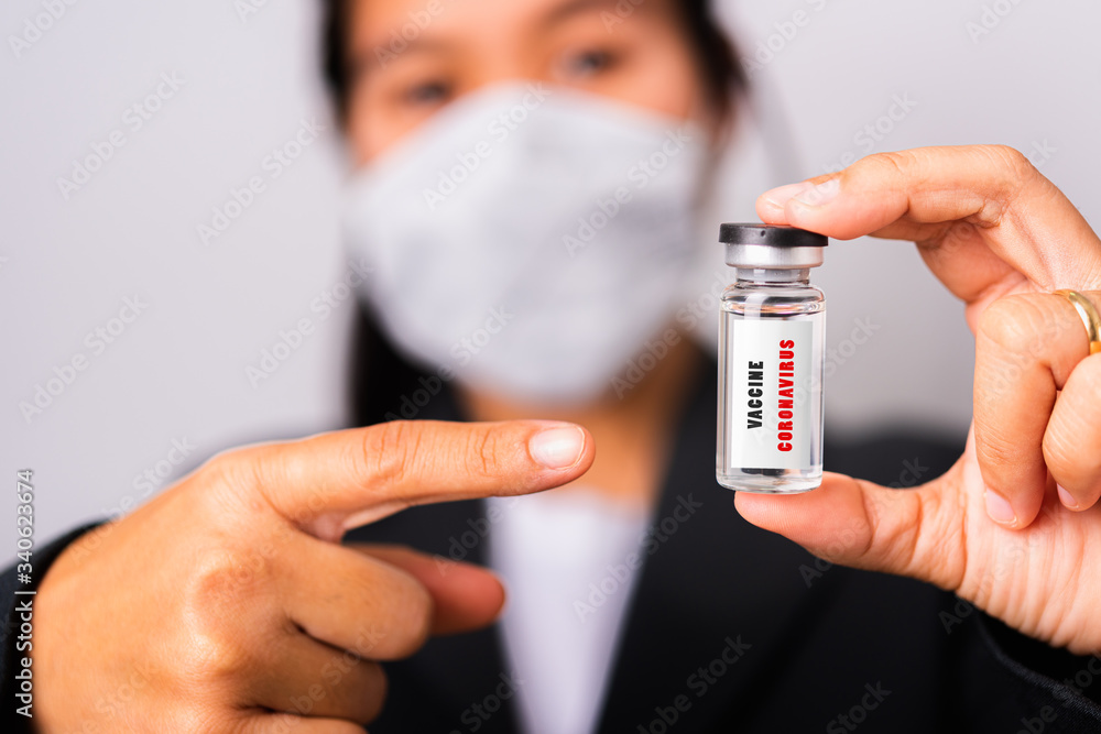 woman doctor wearing surgical protective cloth face mask against coronavirus her pointing ampoule bottle vaccine woman doctor wearing surgical protective cloth face mask against coronavirus her pointing ampoule bottle vaccine
