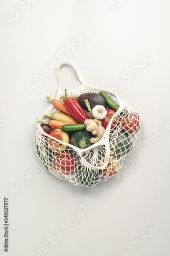 Fresh organic fruits and vegetables in mesh textile bag