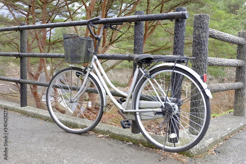 ฺBicycle parked against wooden fence. Vintage bicycle with lock parking in the city
