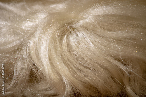 An artificial, white, female wig close-up for those who have little hair on their heads.