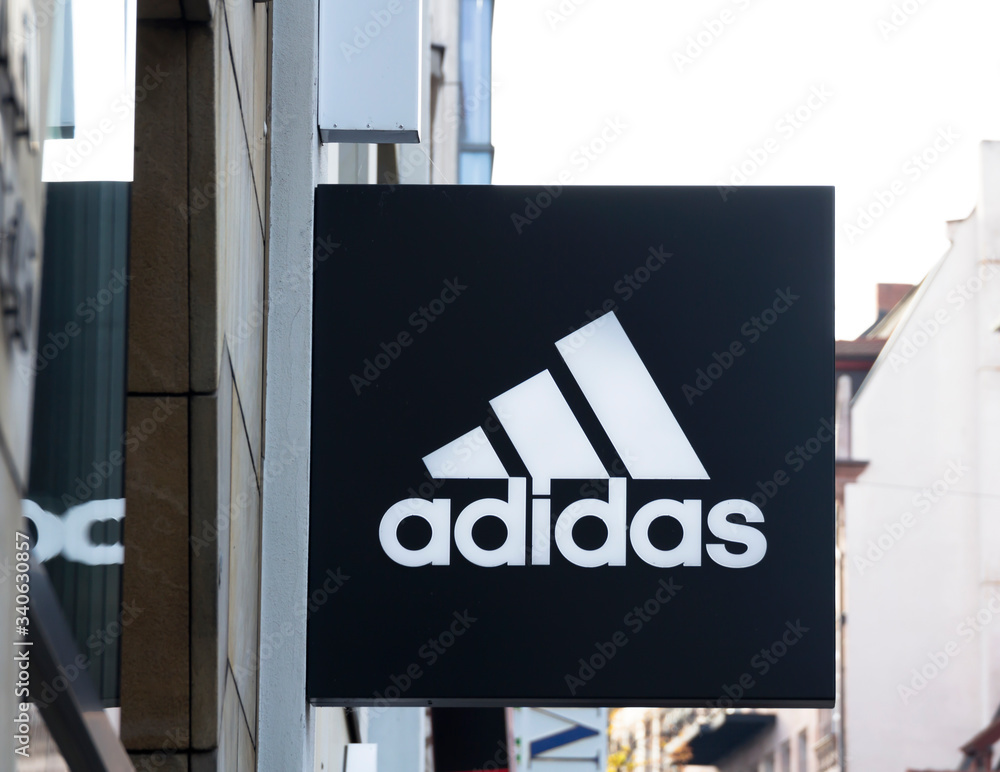 Fotografia do Stock: NURNBERG,GERMANY : Adidas logo on a wall. Adidas is a  German multinational that manufactures sports shoes, clothing. It is the  second biggest sportswear manufacturer in the world | Adobe