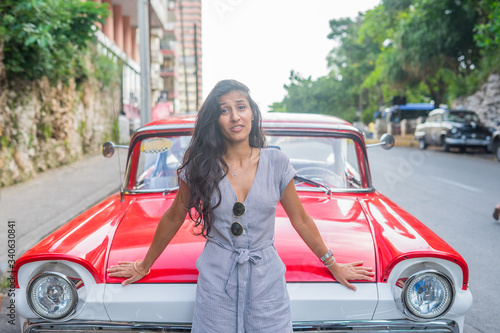 Young indian woman happy in front of red car in Havana © Deboraht