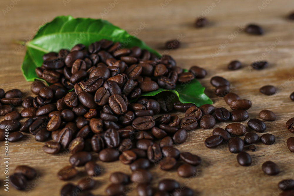 Fototapeta premium Coffee beans on wooden table with copyspace for text. Selective focus.