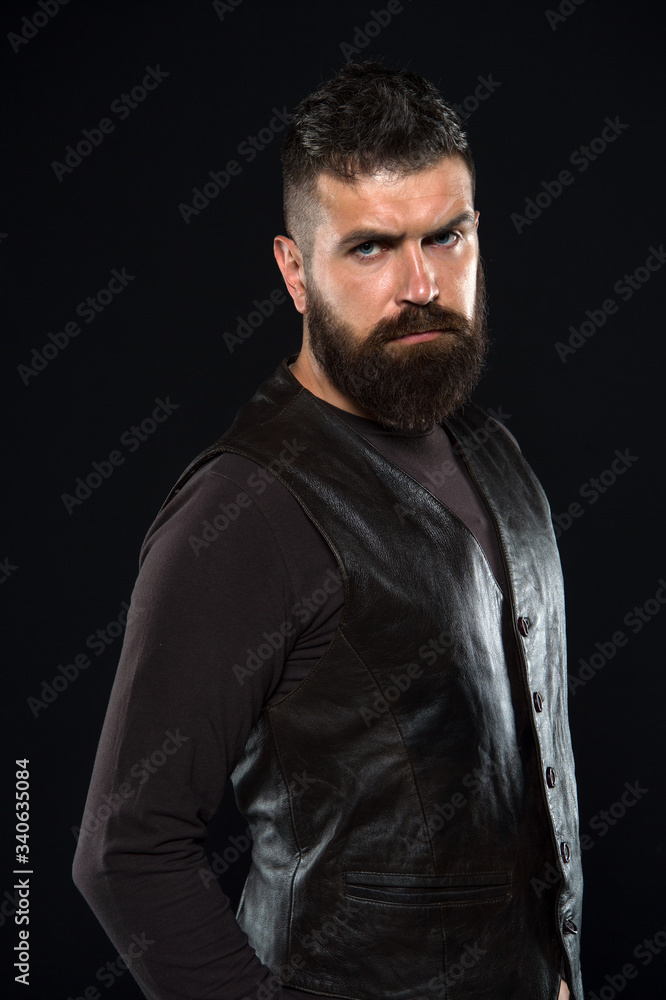 Naklejka premium Man confident and brutal style black background. Barbershop concept. Grow mustache. Fashion model. Strict mature face. Facial hair. Male face. Handsome face. Man with beard in black leather clothes