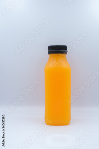 Front view of orange juice glass bottle isolated on white background