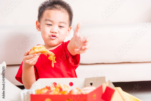 Hot Homemade, Vegetarian fast Italian food, Cute Little Child enjoying eating Delivery Pizza pepperoni, cheese many slices deliciously and show good finger thumb for like in a cardboard box at home