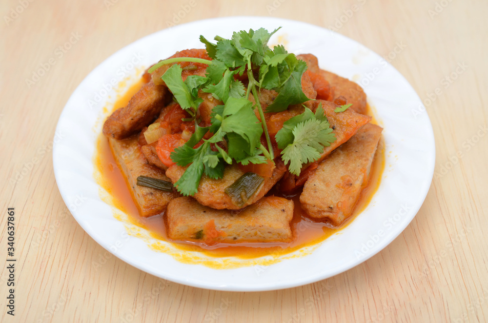fried fishcake slices with stew sauce in plate fried fishcake slices with stew sauce in plate