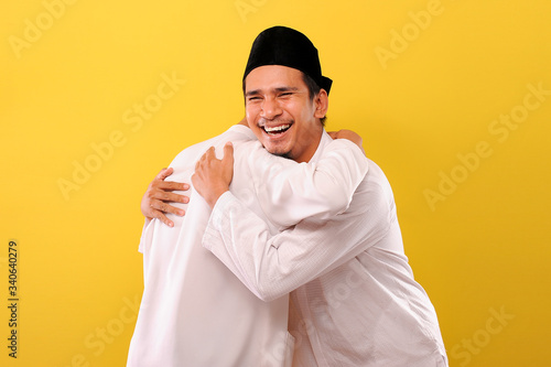 Canvas Print Image of happy two Young Asian Muslim men hugging each other during Eid Mubarak