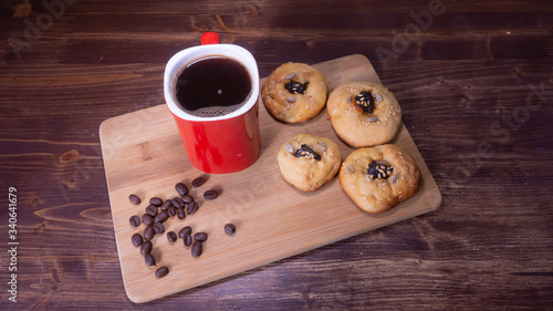 red coffee mug with cookies and coffee beans