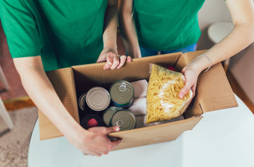 Volunteer with box of food for poor. Donation concept.