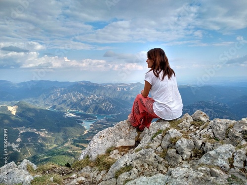 a woman on top of a mountain looking at the landscape