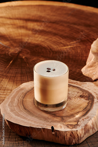 glass with coffee on a wooden background.
cappuccino decorated with coffee beans on wooden background