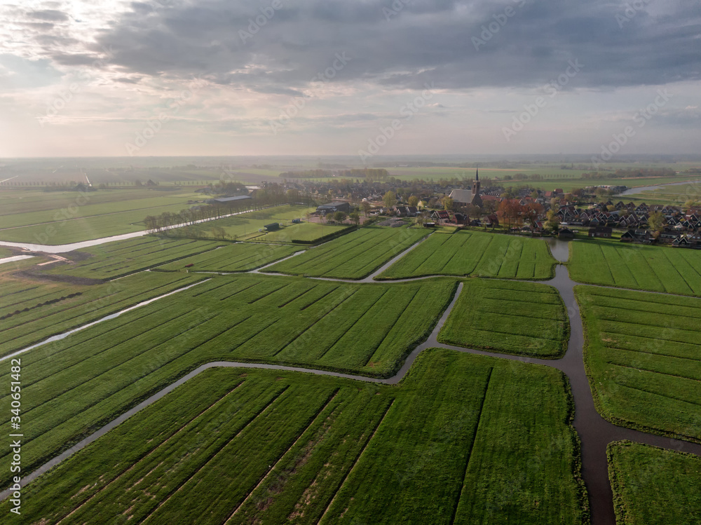 Aerial view of dutch green meadow land with water canals and small village