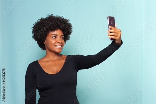 black woman with black power hair making a selfie with her smartphone