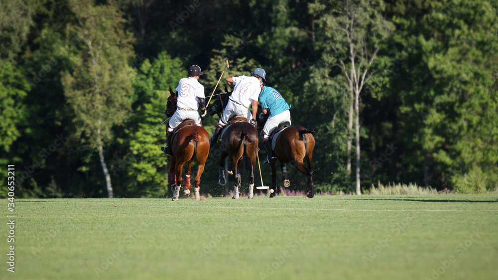 Three horse Polo players with a mallet in game action Three horse Polo players with a mallet in game action