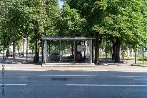 Bus stop of Rijeka, Croatia in front of the trees and by the road during hot summer day. June 2019