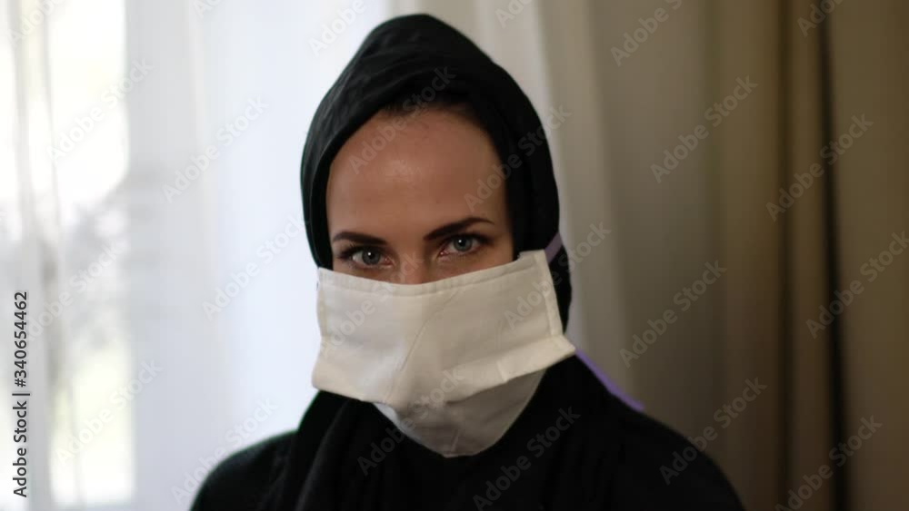 Cute arabic muslim woman wearing disposable face mask on interior. Cute arabic muslim woman wearing disposable face mask on interior.