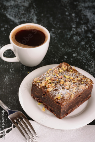 Brownie cake and freshly brewed black coffee for breakfast or dessert on a dark background