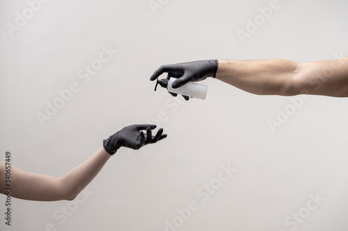 Hands in black silicone gloves on a light background.