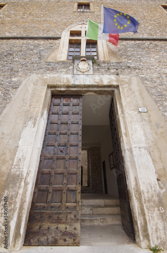 The large entrance door of the Piccolomini Castle of Capestrano, you can see the flag of Italy and Europe - Abruzzo - Italy photo