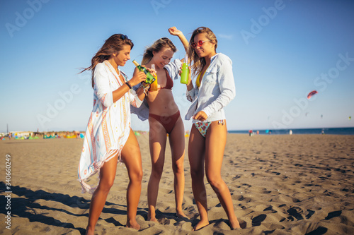 Group of three beautiful attractive young women having fun on the beach.