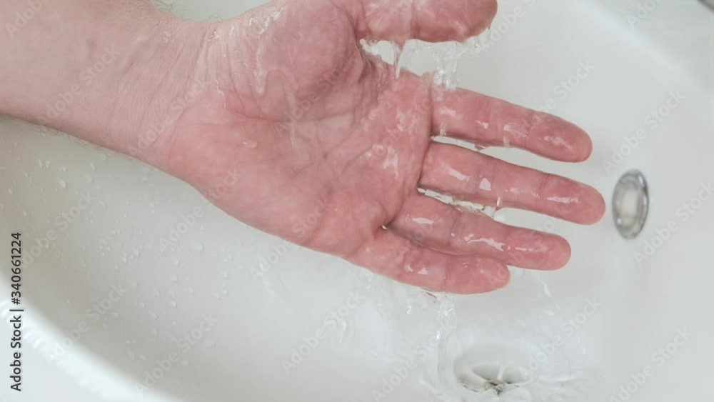 Simple hand hygiene. Water from the tap flows into the sink, a person washes his hands. Simple hand hygiene. Water from the tap flows into the sink, a person washes his hands.