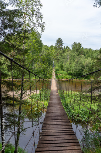 Suspension bridge over the Serga river in Deer streams national Park. Sverdlovsk region, Ural, Russia.