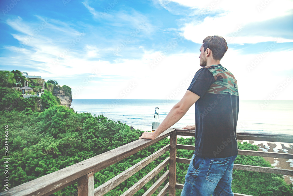 Enjoying drinking beer and looking at distant seascape on a vacation. Enjoying drinking beer and looking at distant seascape on a vacation.