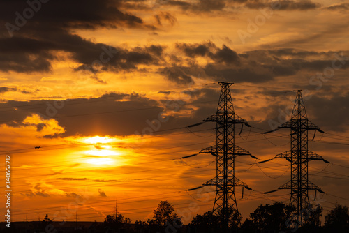 Power lines in the setting sun. A line of high-voltage wires against the sky. Sunset in the Moscow region.
