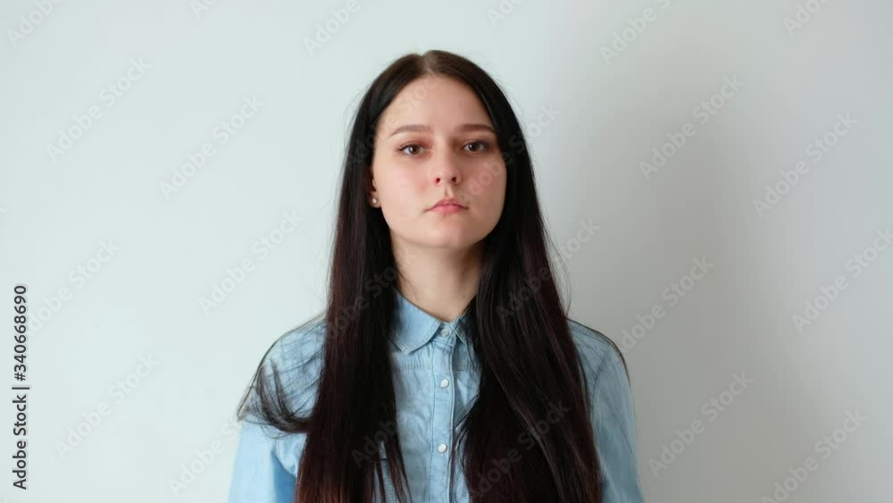 closeup of a young smiling woman girl with long brown hair puts off a medical protective mask, looks at the camera, covid-19 hygiene concept, coronavirus, on a white background, white wall home closeup of a young smiling woman girl with long brown hair puts off a medical protective mask, looks at the camera, covid-19 hygiene concept, coronavirus, on a white background, white wall home