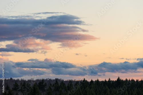 Beautiful sunset clouds on sky over forest horizon