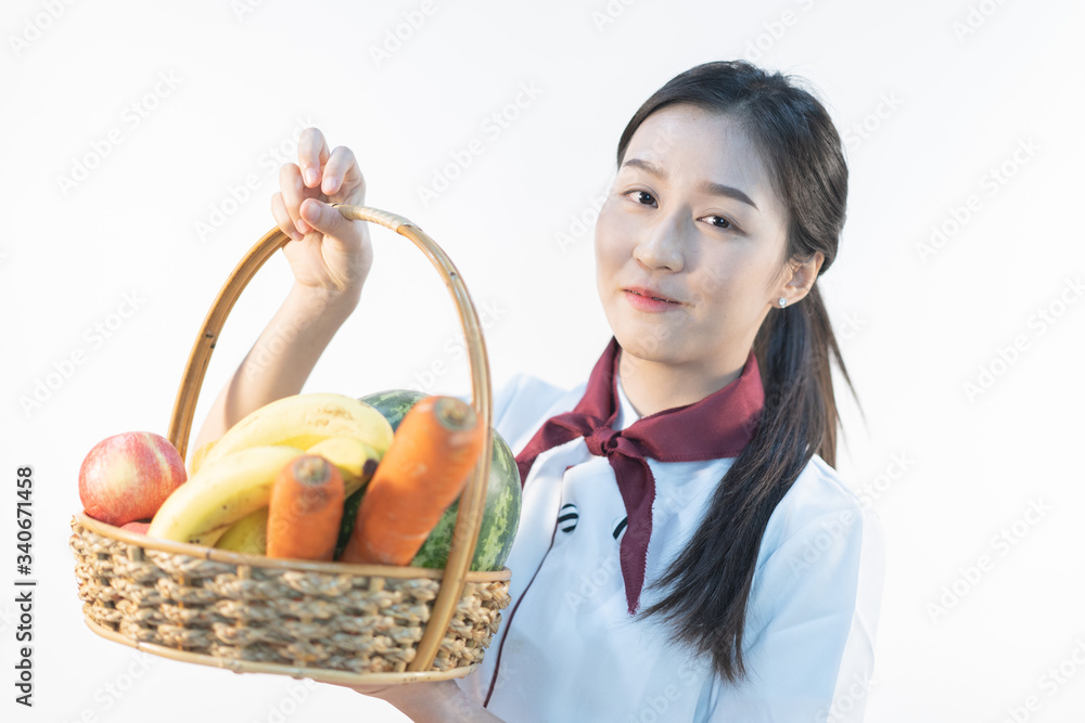 A cute girl makes vegetable juice, with carrot apple orange cranberry beetroot and mango in chef suit. A cute girl makes vegetable juice, with carrot apple orange cranberry beetroot and mango in chef suit.