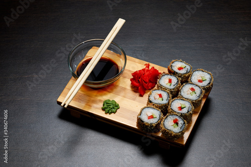 Tasty and delicious hot and cold sushi rolls on the table. Different sushi - rolls with sauce on the board of Japanese cuisine. photo