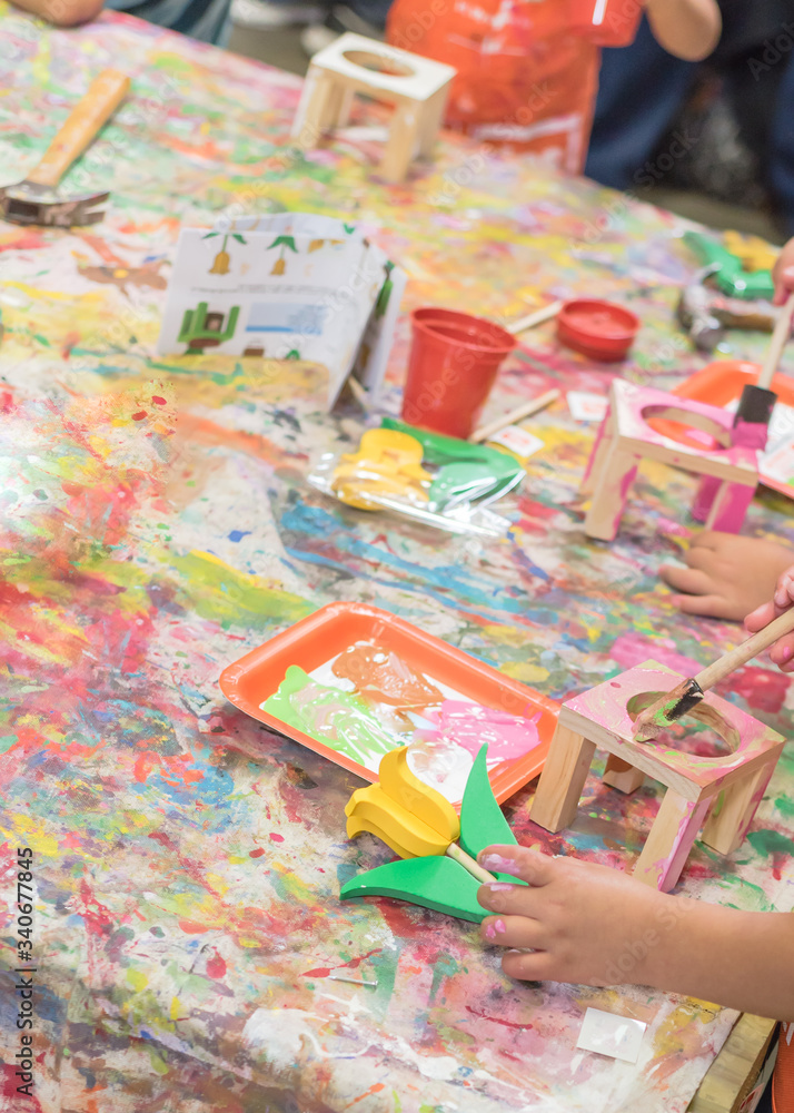 Fototapeta premium Kid hands painting craft at building workshop in local hardware store in Texas, USA