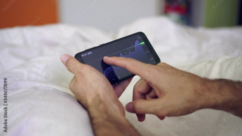 A person at home invests or works on the exchange using a smartphone A person at home invests or works on the exchange using a smartphone