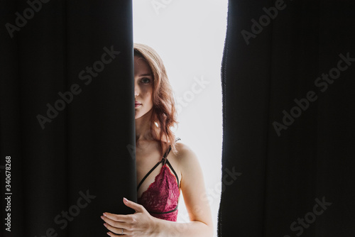 Beautiful young woman in underwear near the window.