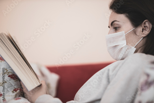 girl reading a book in her home during the coronavirus outbreak