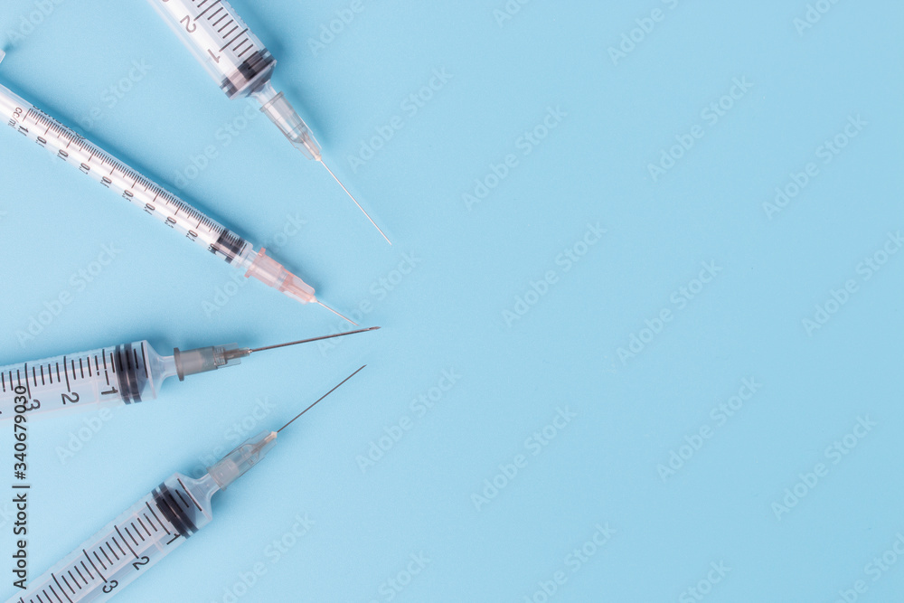 Close-up of medical syringe on blue background. Close-up of medical syringe on blue background.