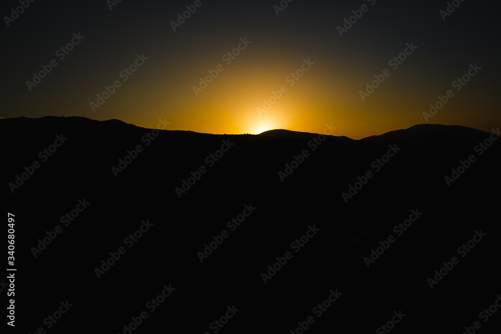 mountain silhoette of austrian alps at sunrise glowing sky