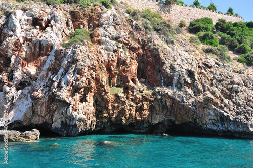 Rocky and cliff shore over the sea. Turquoise-coloured seawater.