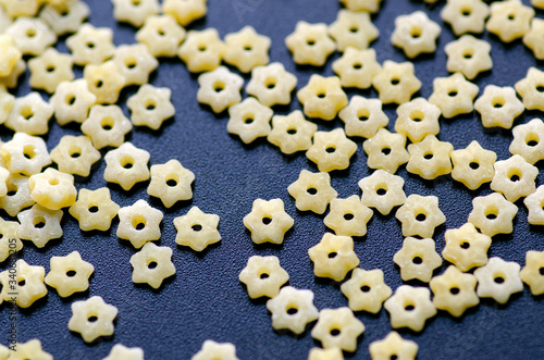 Raw stelline pasta close-up lay evenly on a black background